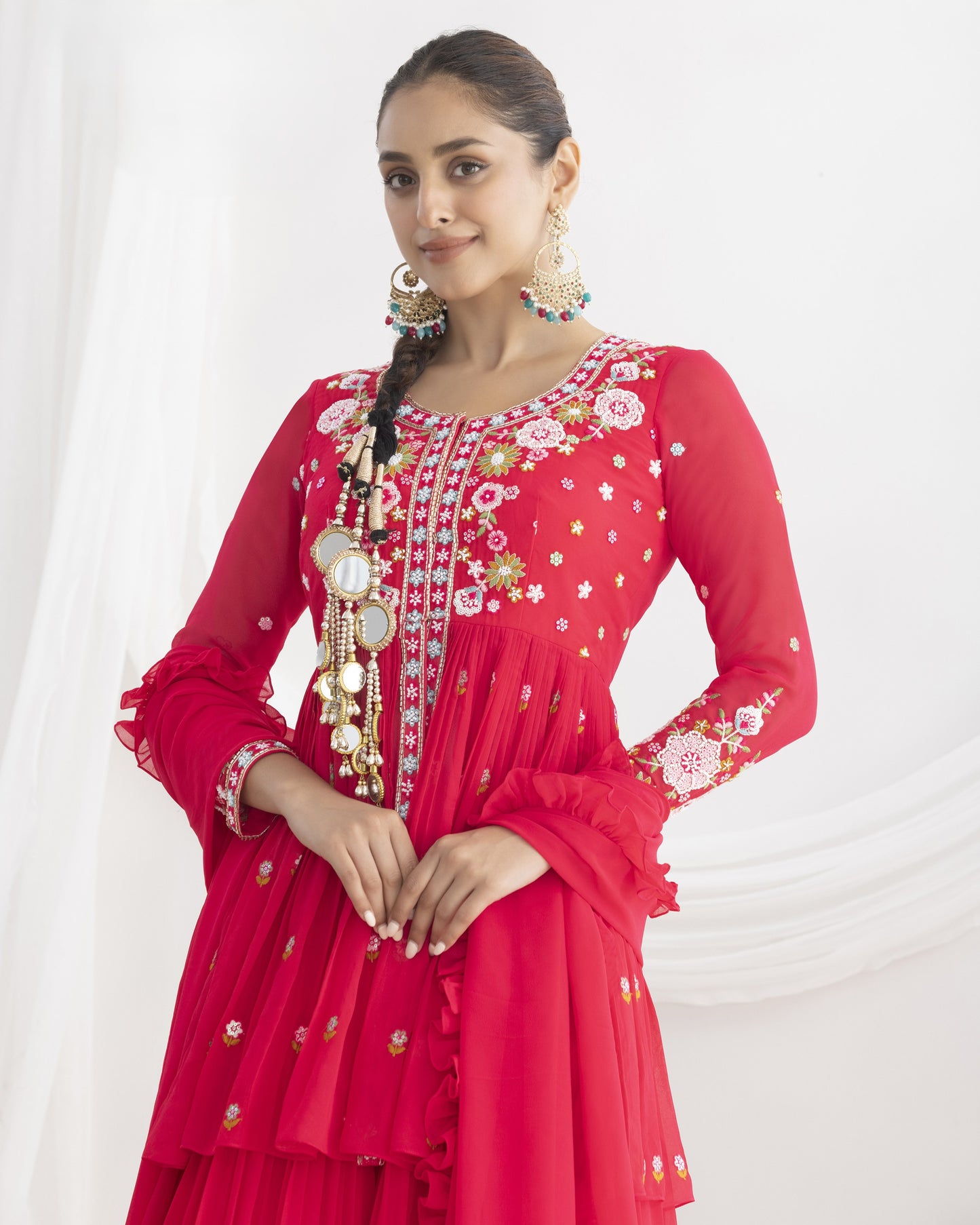 Woman wearing a red embroidered traditional outfit on a white background