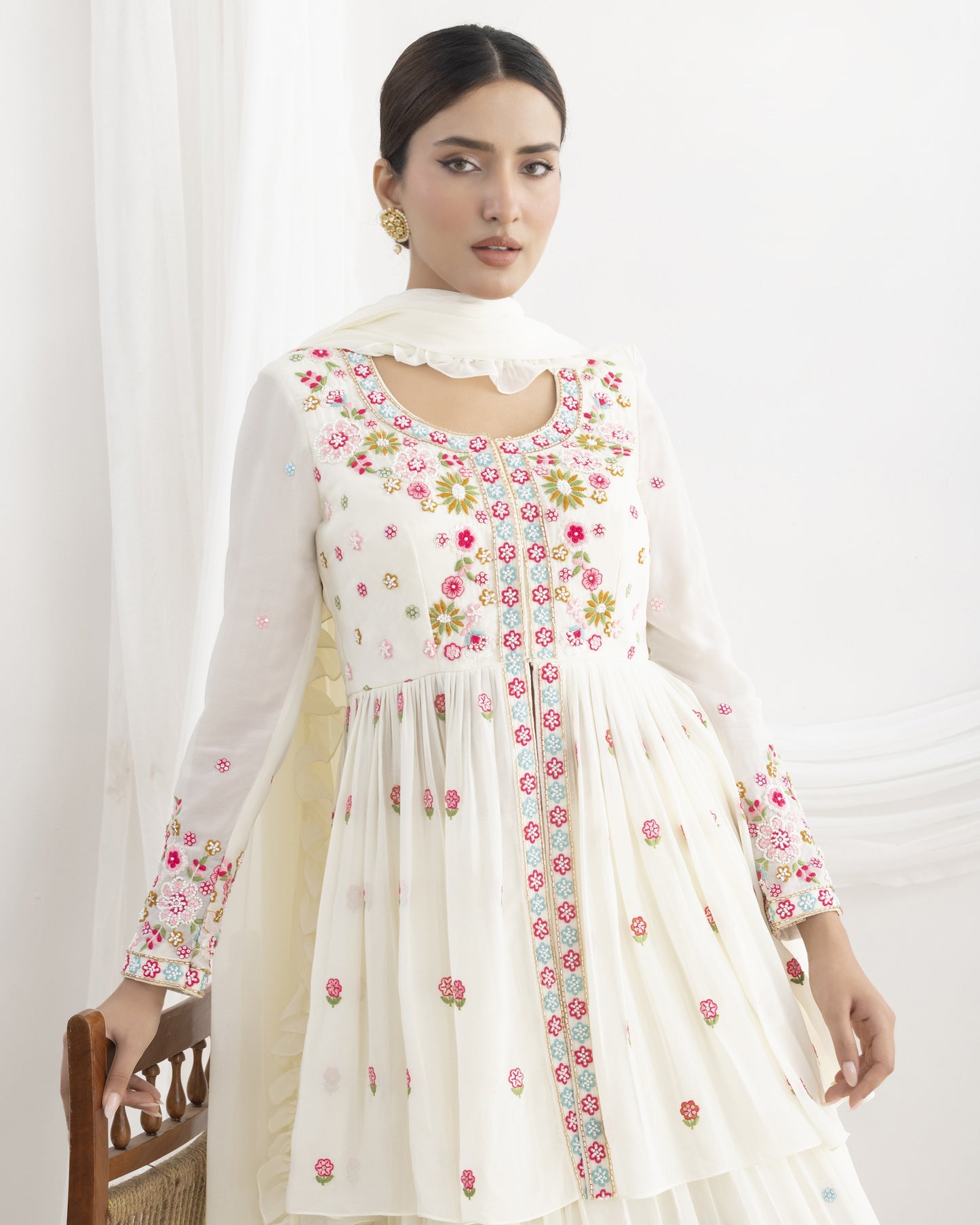 Woman wearing a white dress with floral patterns on a white background