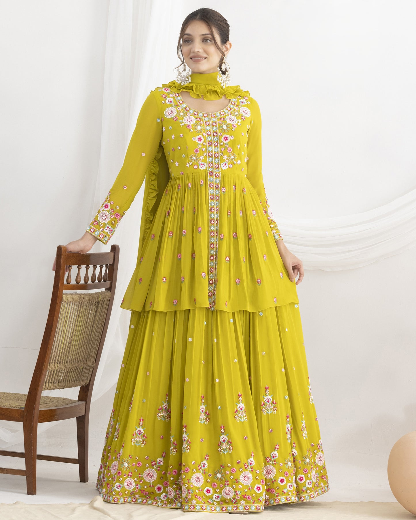 Woman wearing a yellow floral dress against a white background