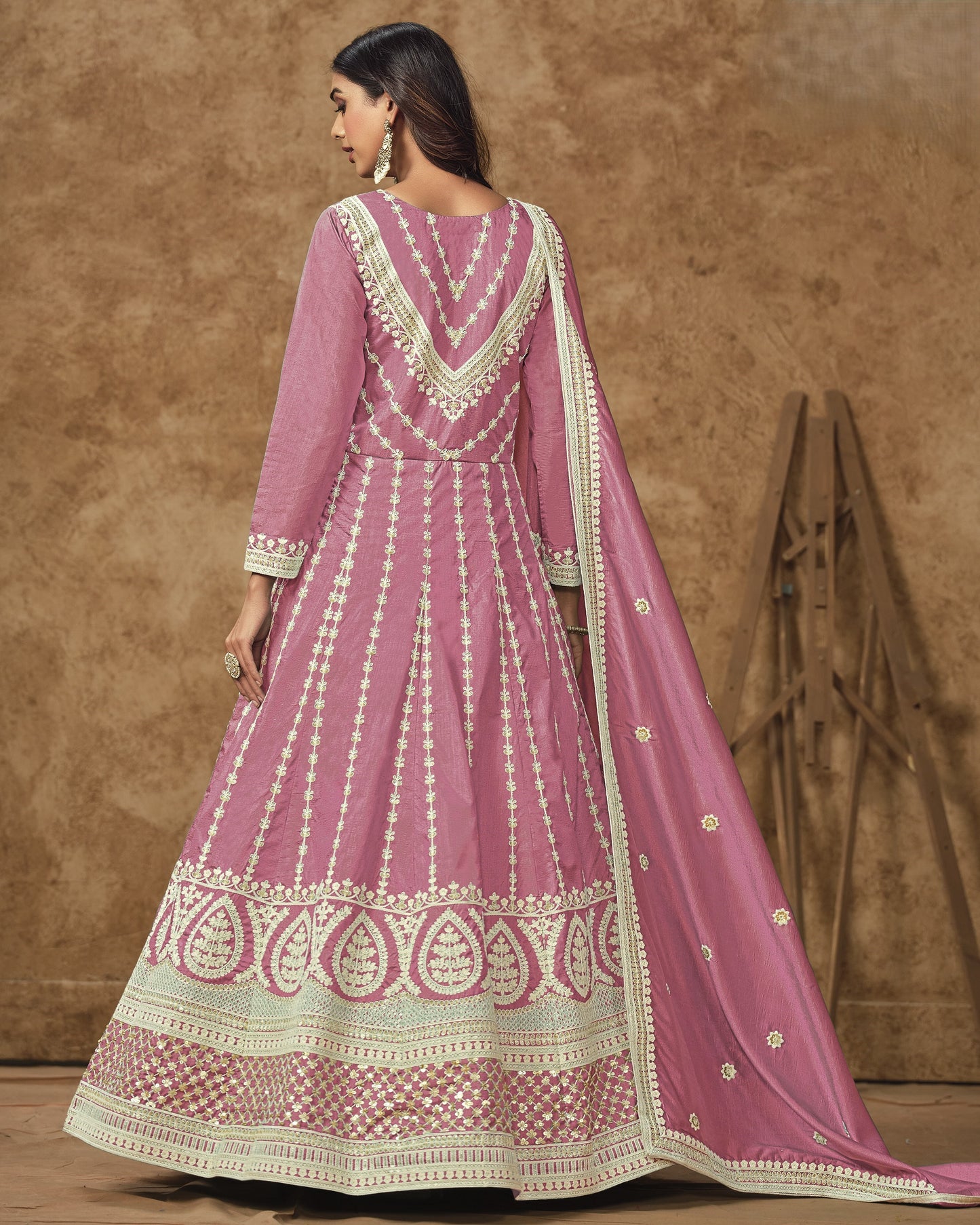 Pink traditional outfit with white embroidery on a brown background