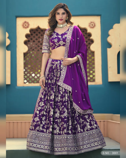 Woman wearing a purple traditional outfit with floral patterns against a decorative wall.