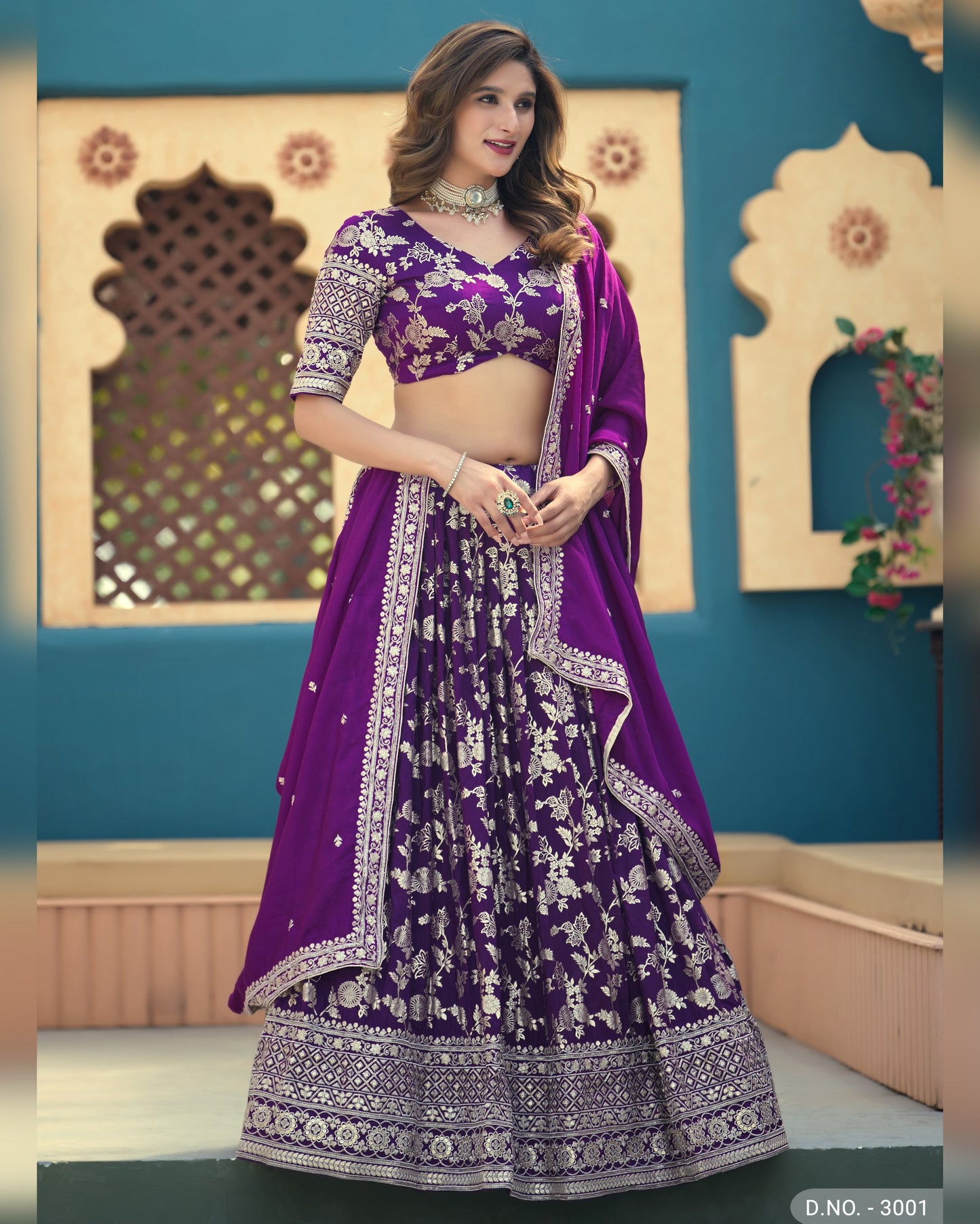 Woman wearing a purple traditional outfit with intricate designs in a decorated room.