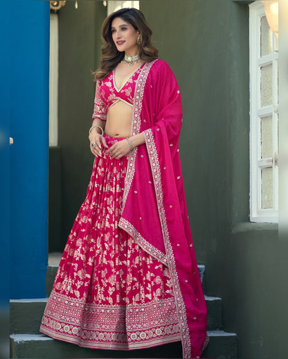 Woman in a pink traditional outfit standing on steps with a blue wall and window in the background