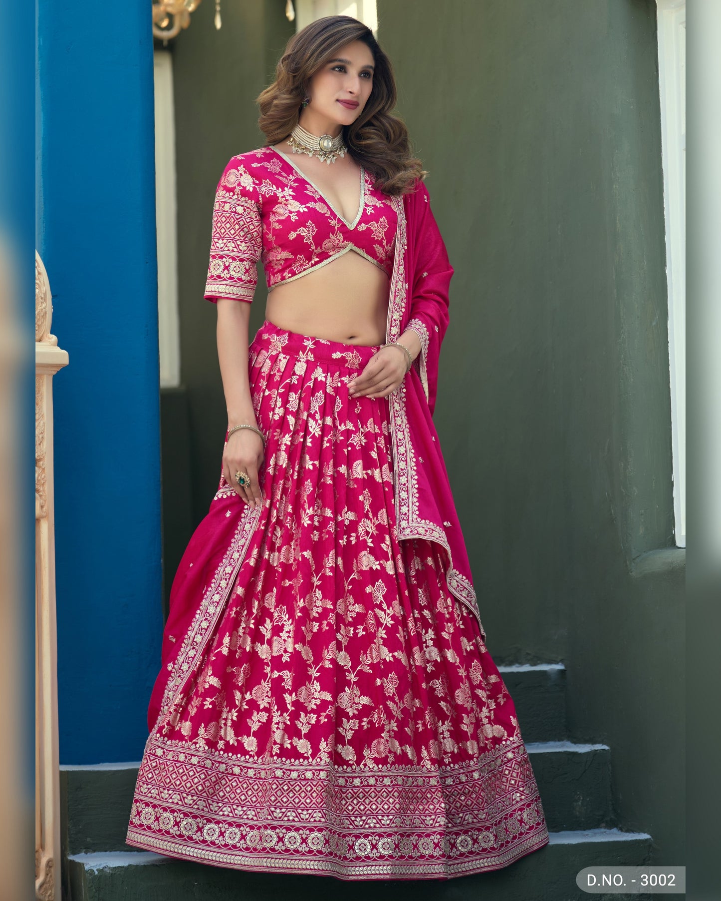 Woman wearing a pink traditional outfit with white patterns on a blue and gray background