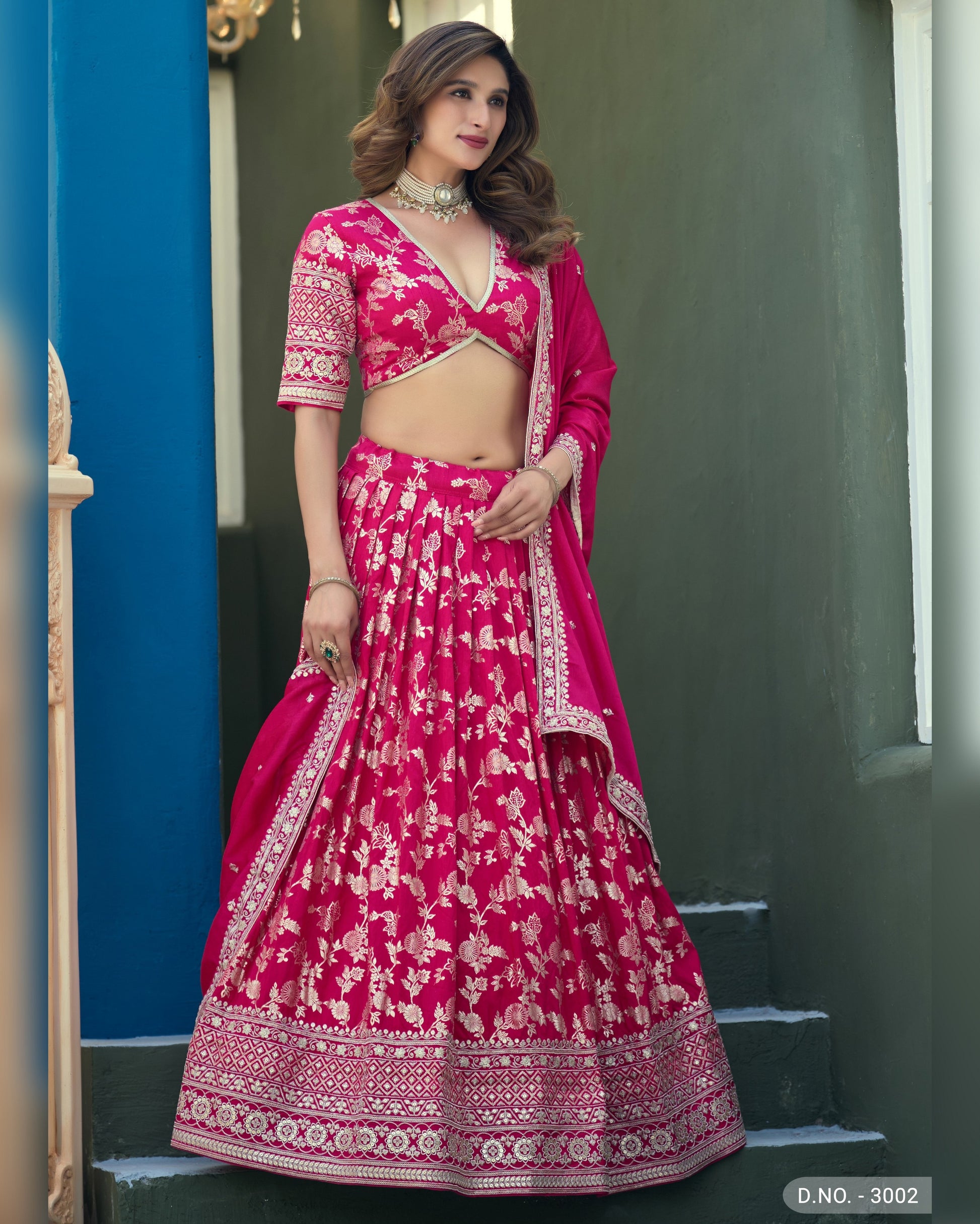 Woman wearing a pink traditional outfit with white patterns on a blue and gray background