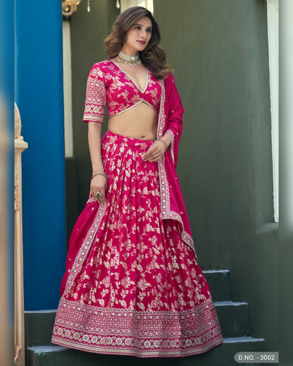 Woman wearing a pink traditional outfit with white patterns on a blue and gray background
