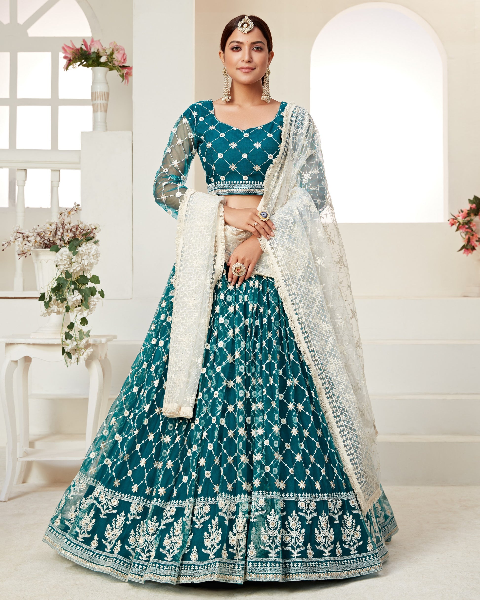Woman wearing a teal and white traditional outfit with a white background
