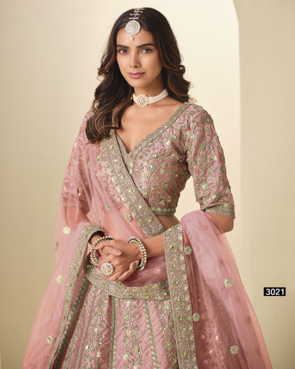 Woman wearing a pink traditional outfit with intricate designs on a beige background