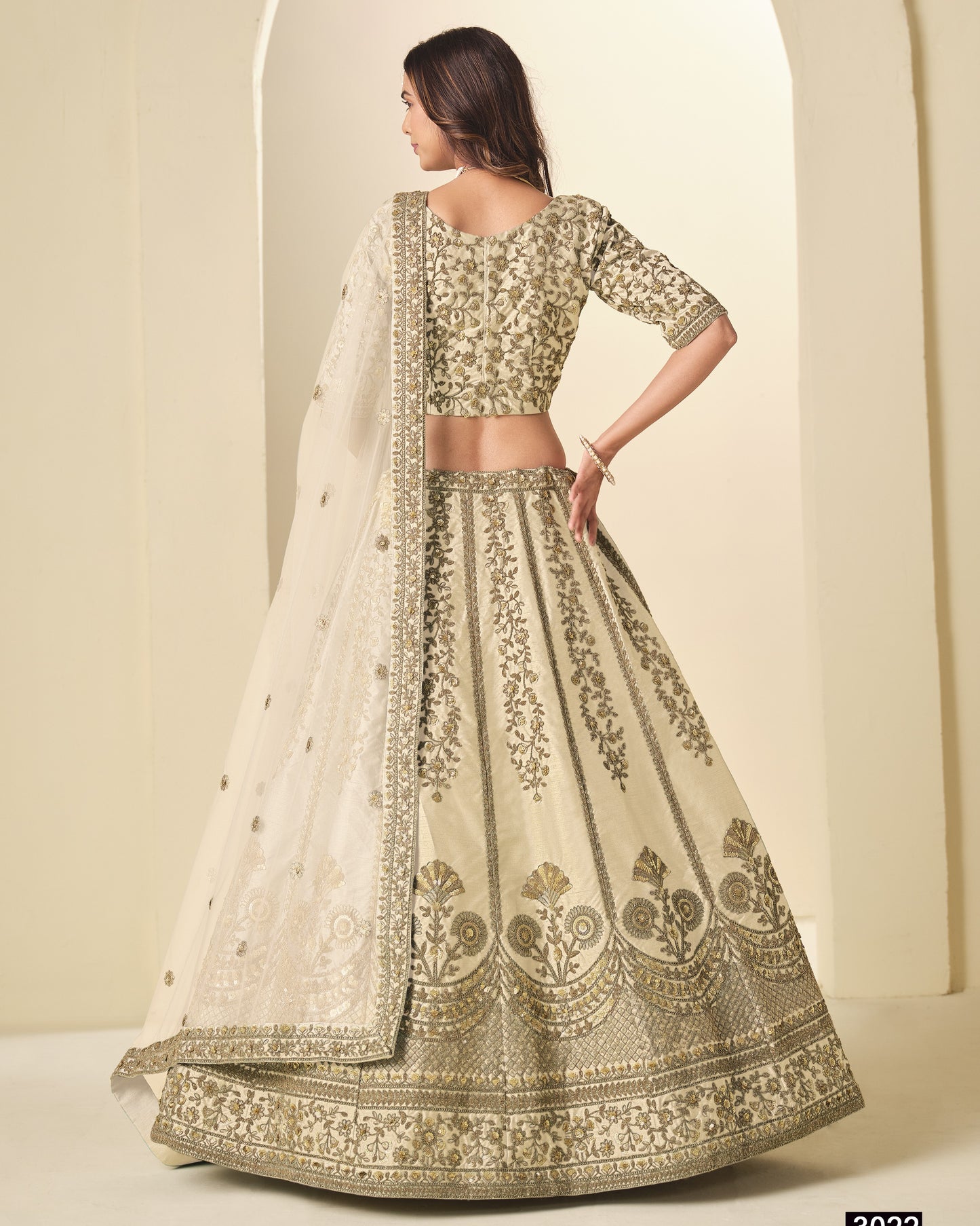 Woman wearing a traditional embroidered outfit with a plain background