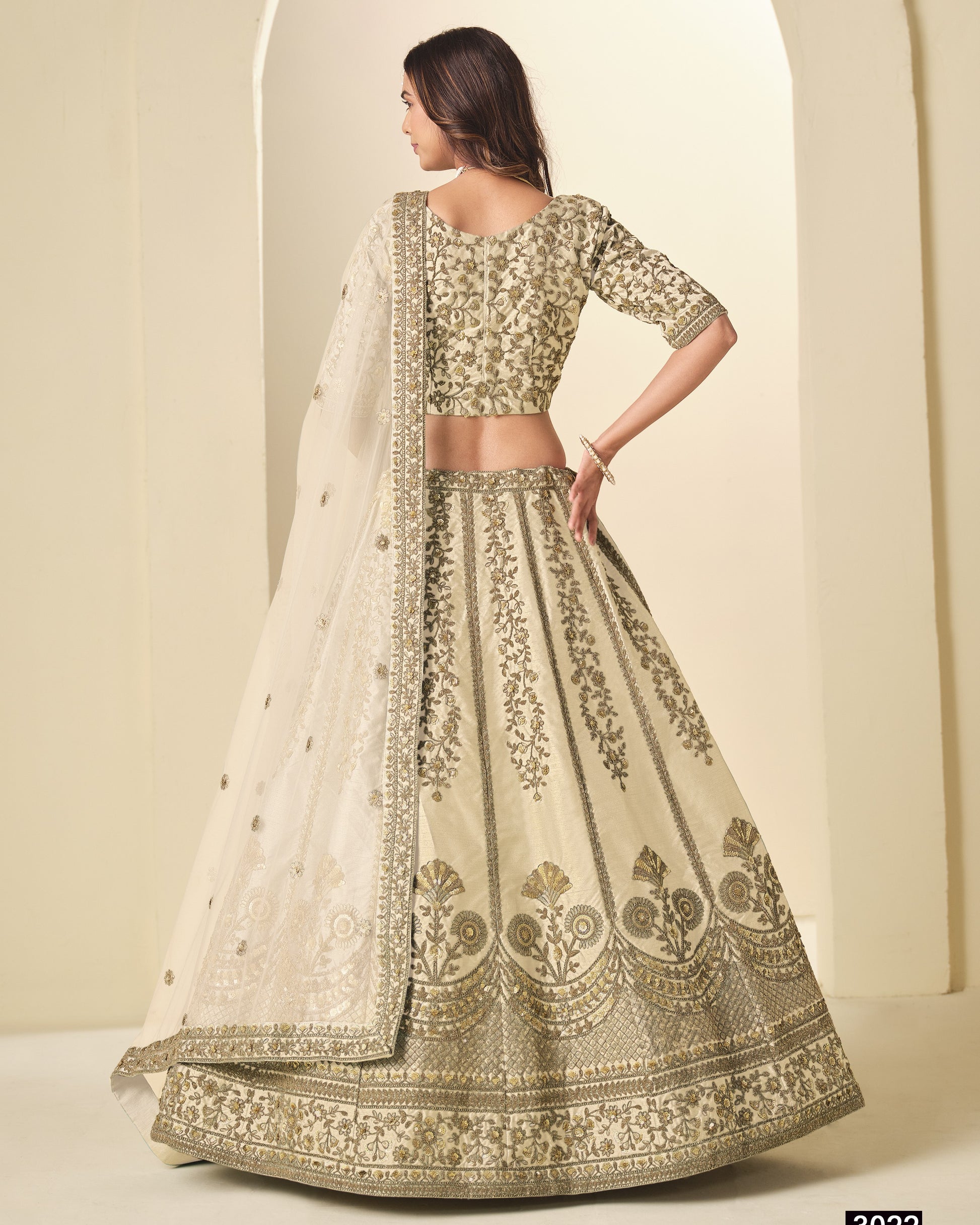 Woman wearing a traditional embroidered outfit with a plain background