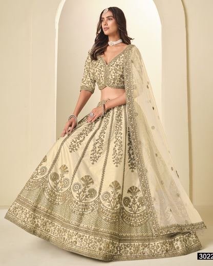 Woman wearing a traditional embroidered lehenga in a neutral setting