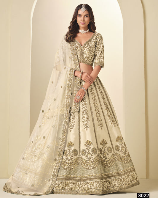 Woman wearing a traditional embroidered lehenga in a neutral setting