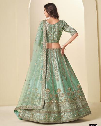 Green embroidered traditional outfit with a plain background