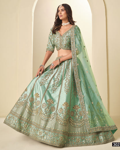 Woman wearing a light green embroidered traditional outfit with a beige background