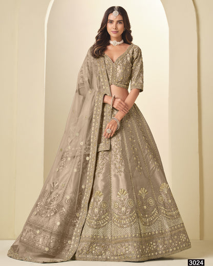 Woman wearing a traditional embroidered lehenga with a plain background