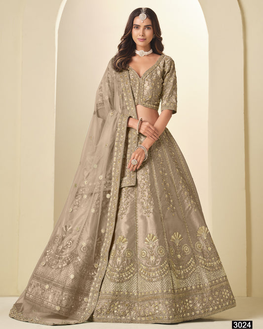 Woman wearing a traditional embroidered lehenga with a plain background