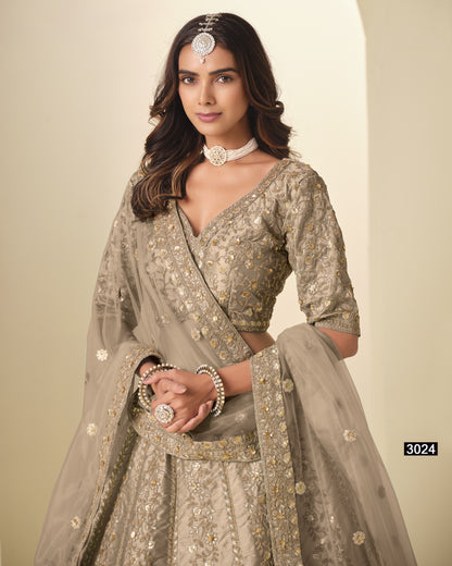 Woman wearing a traditional embroidered outfit with a plain background