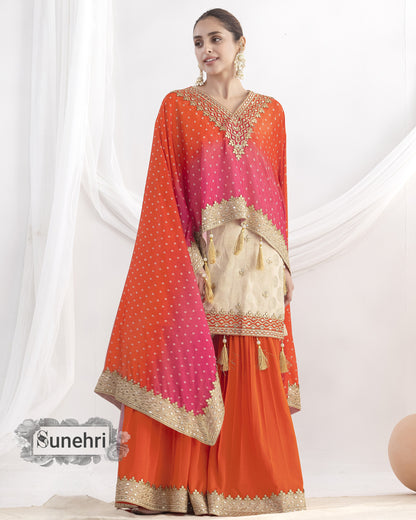 Woman wearing an orange and pink traditional outfit with a matching dupatta on a white background