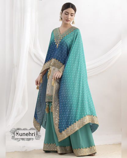 Woman wearing a teal and blue traditional outfit with gold accents against a white background