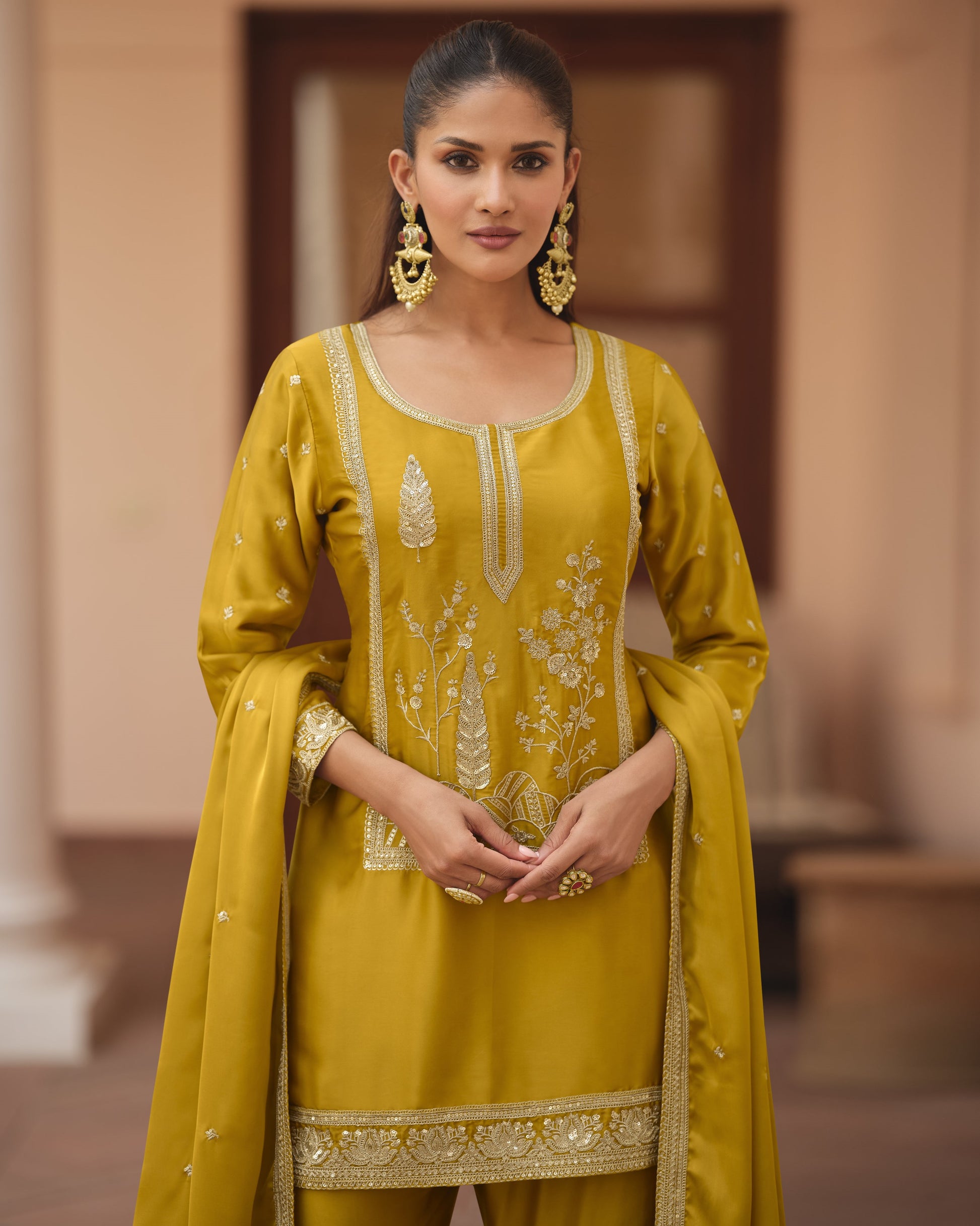 Woman wearing a yellow embroidered traditional outfit with a blurred background