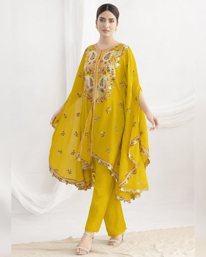 Woman wearing a yellow traditional outfit with floral patterns on a white background