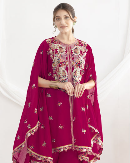 Woman wearing a magenta embroidered traditional outfit on a white background