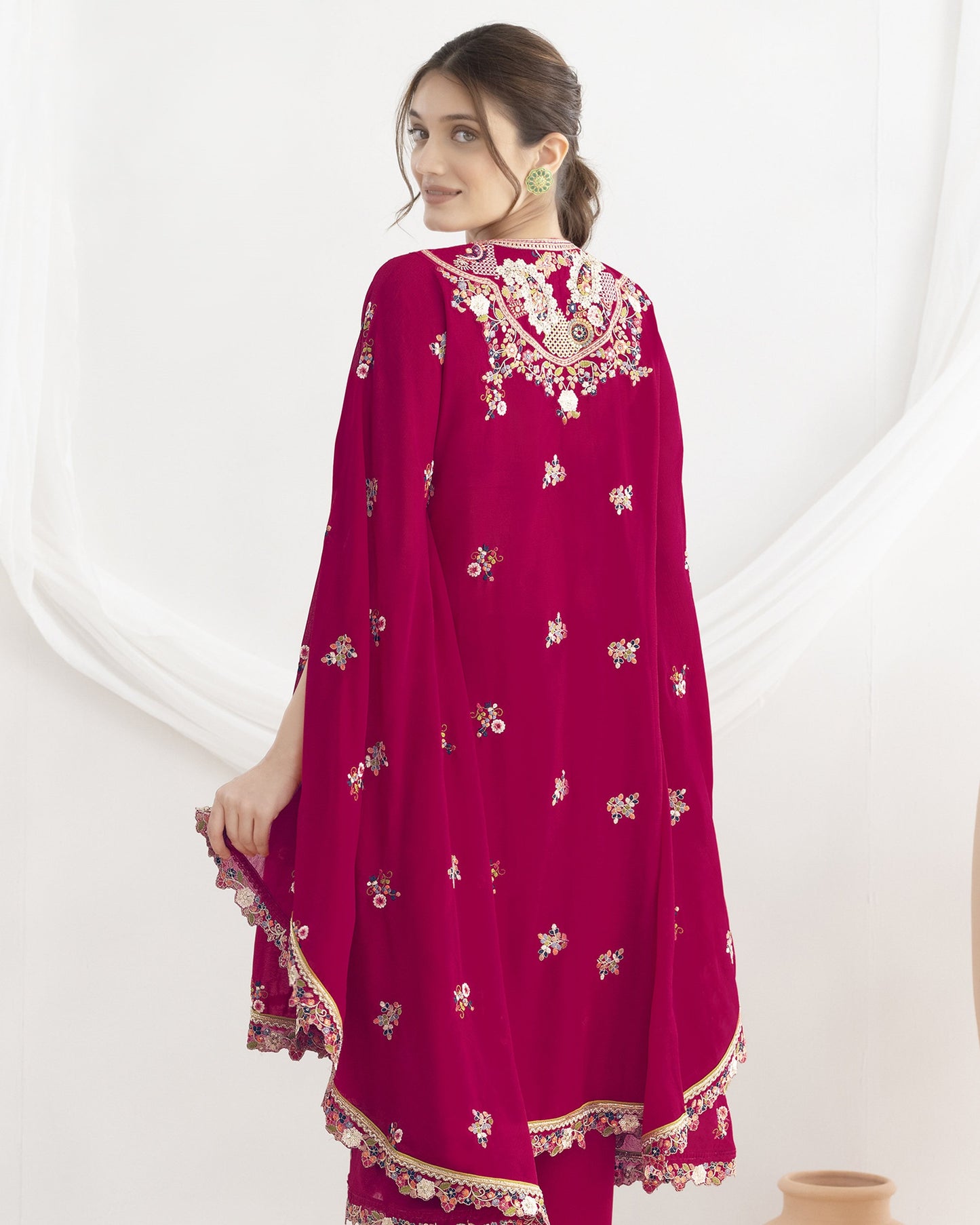 Woman wearing a red embroidered traditional outfit on a white background
