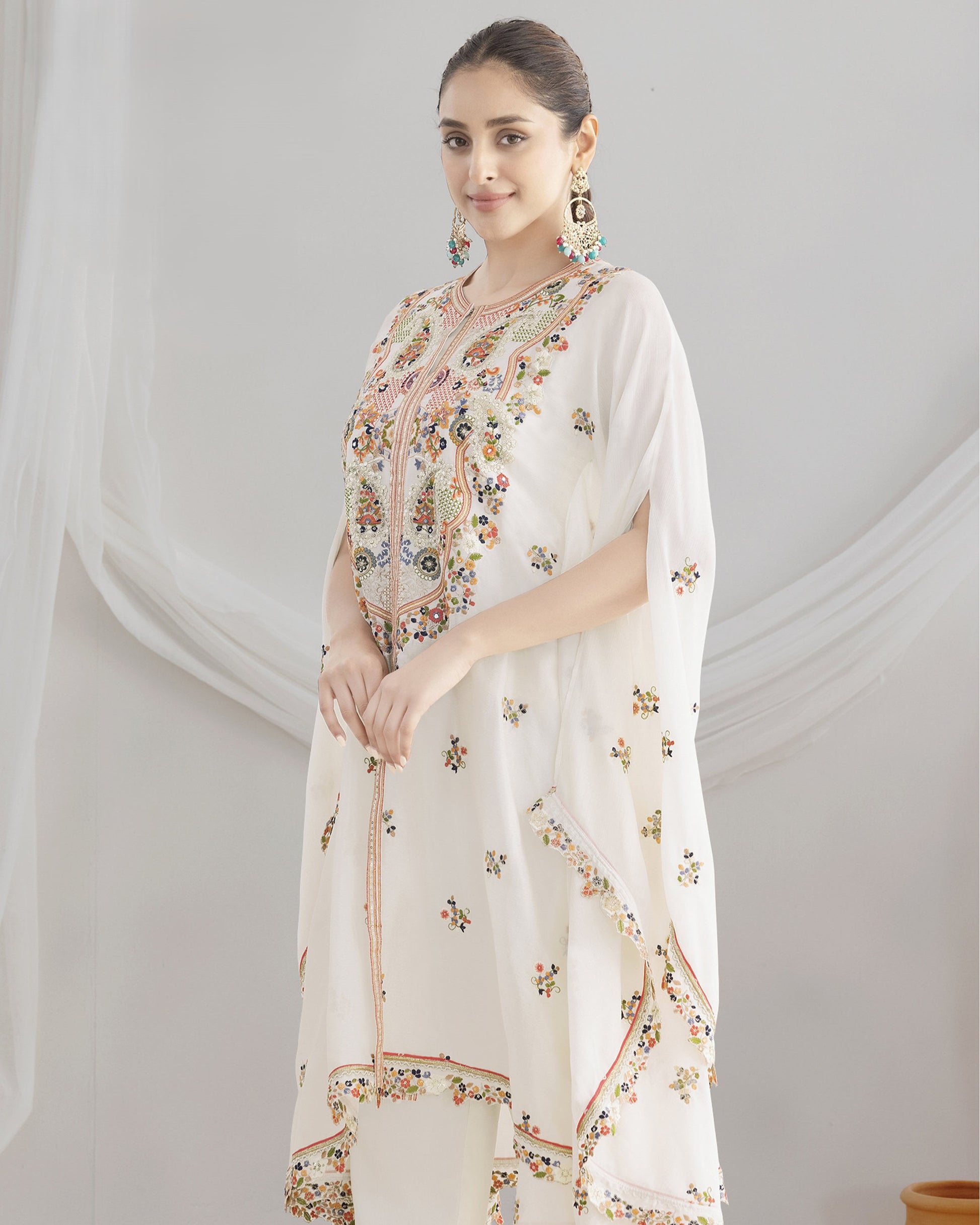 Woman wearing a white floral dress against a light gray background