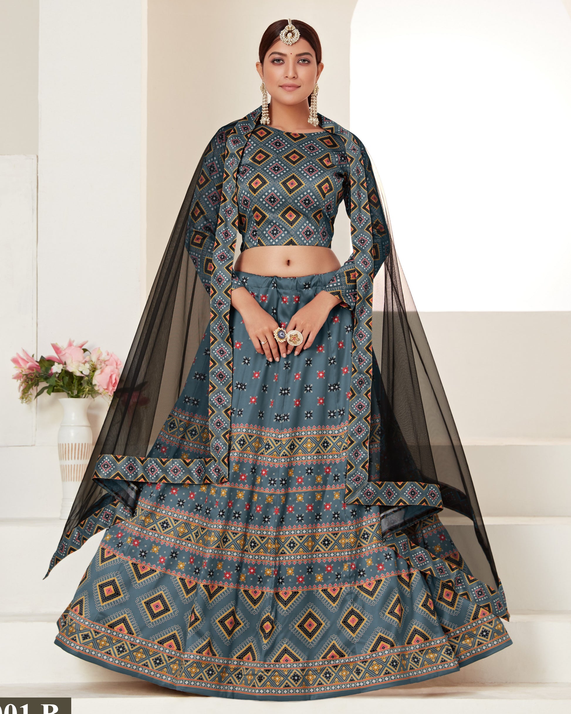 Woman wearing a traditional blue patterned outfit with a black dupatta on a white background