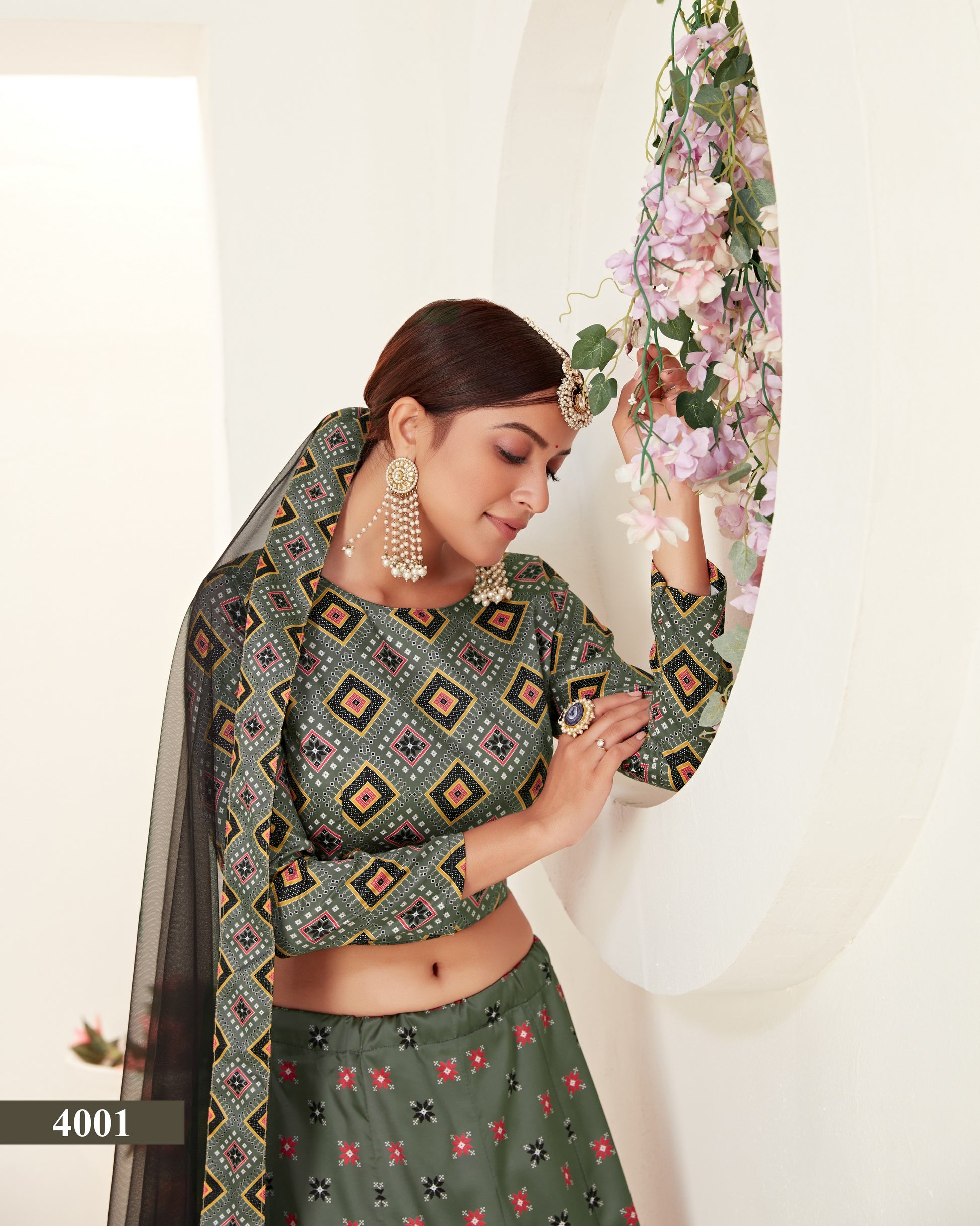 Woman wearing a green patterned saree with a white background