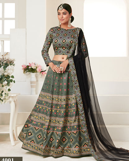 Woman wearing a traditional patterned outfit with a black dupatta in a bright room.