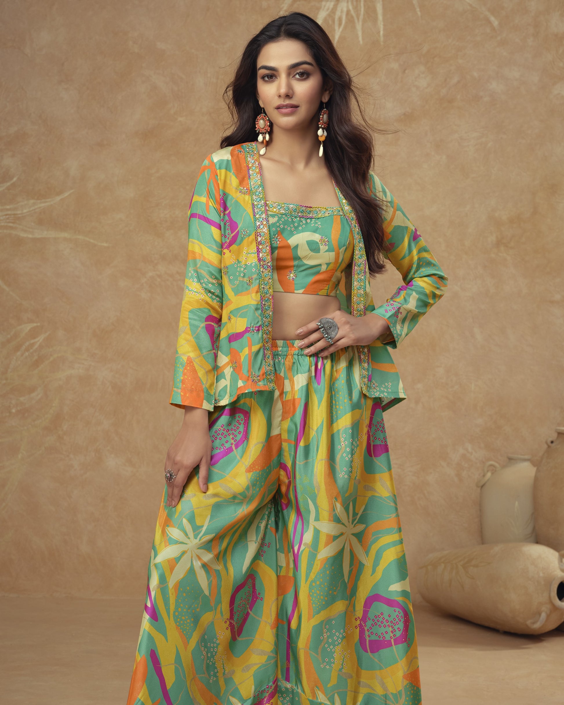 Woman wearing a colorful traditional outfit with a patterned jacket and pants against a beige background.