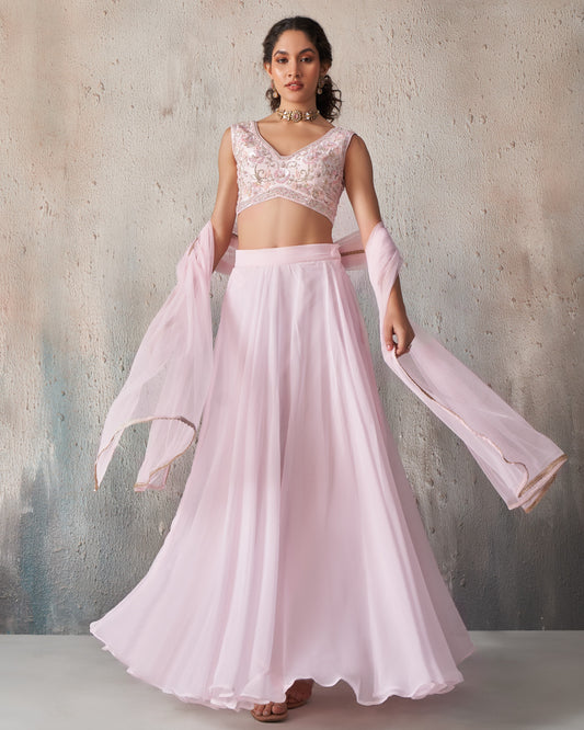 Woman wearing a pink traditional outfit with a textured gray background