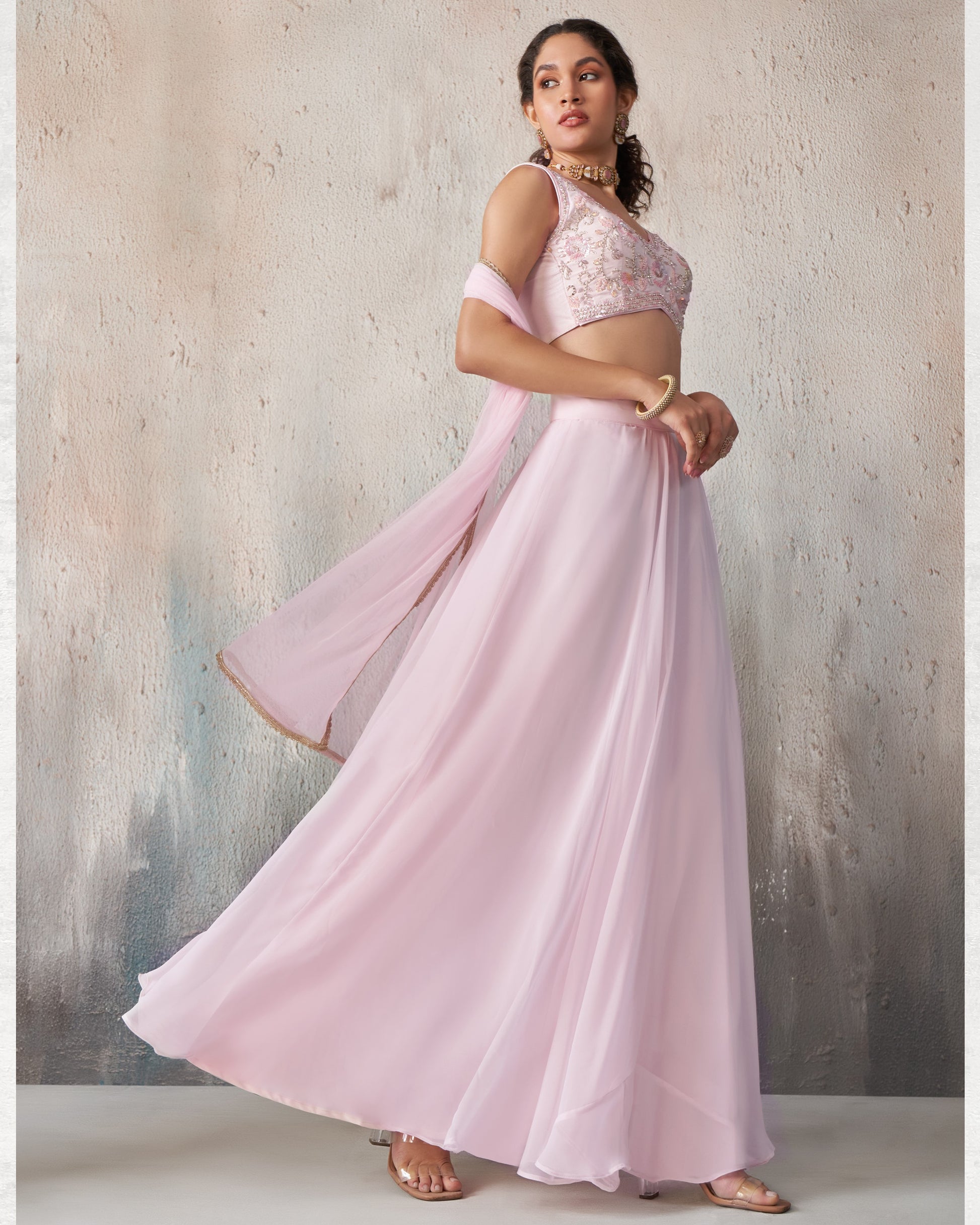 Woman wearing a pink traditional outfit with a textured background