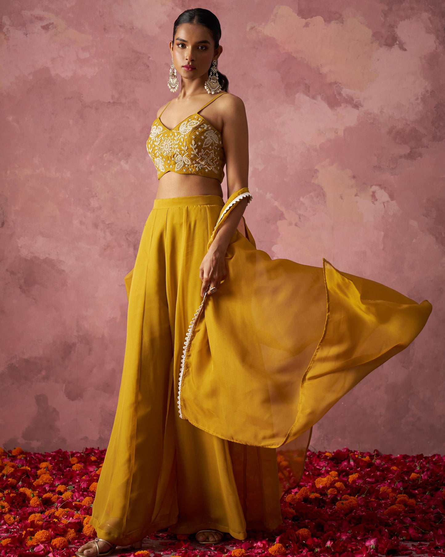 Woman in a yellow traditional outfit with a floral background