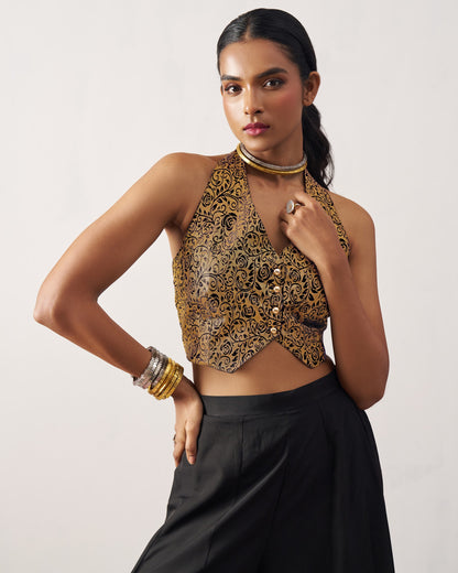 Woman wearing a patterned top and black skirt on a plain background