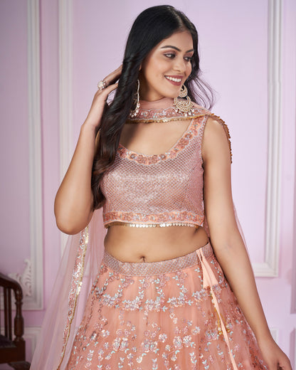 Woman wearing a pink embroidered traditional outfit against a light purple wall.