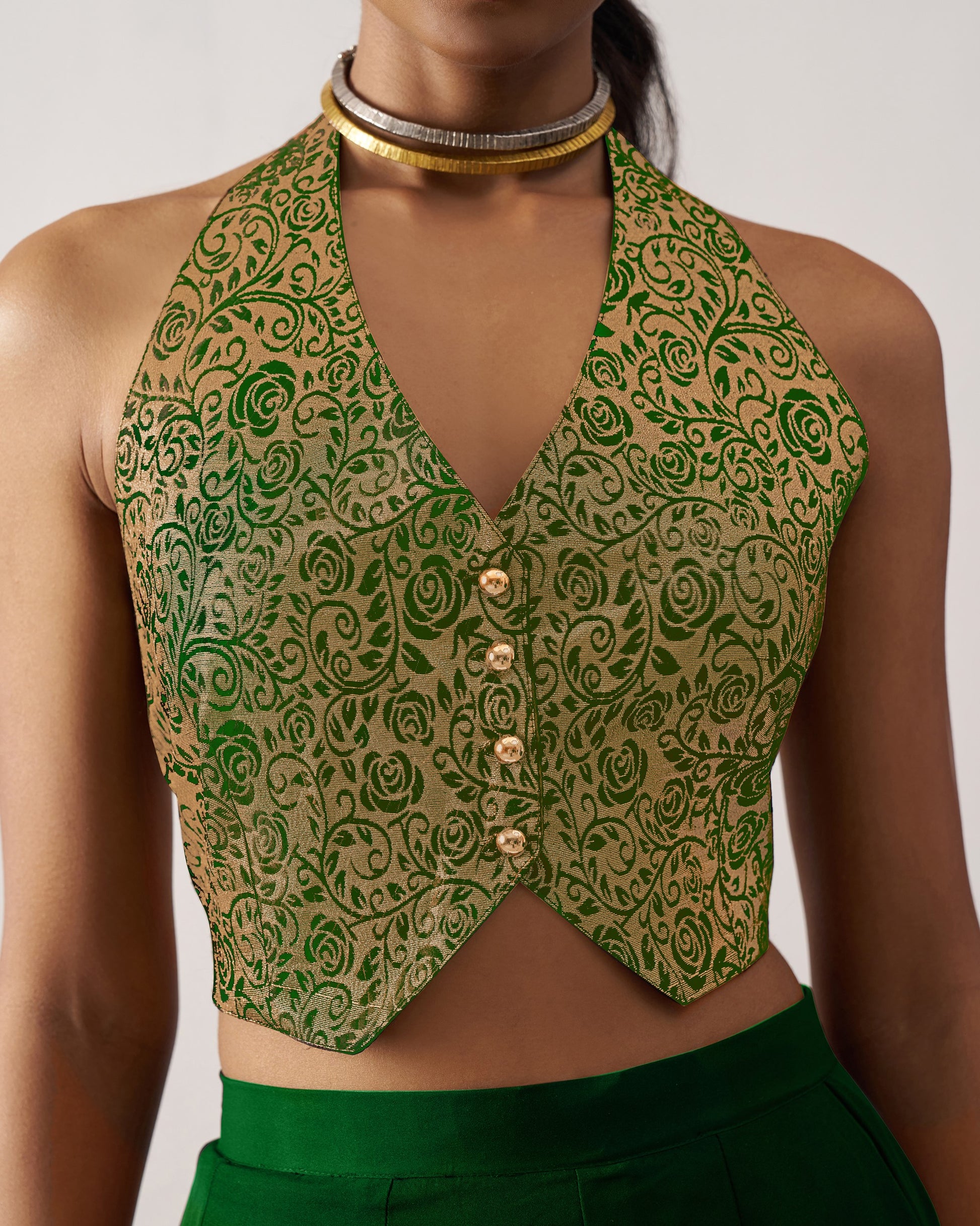 Green patterned crop top worn by a person on a plain background