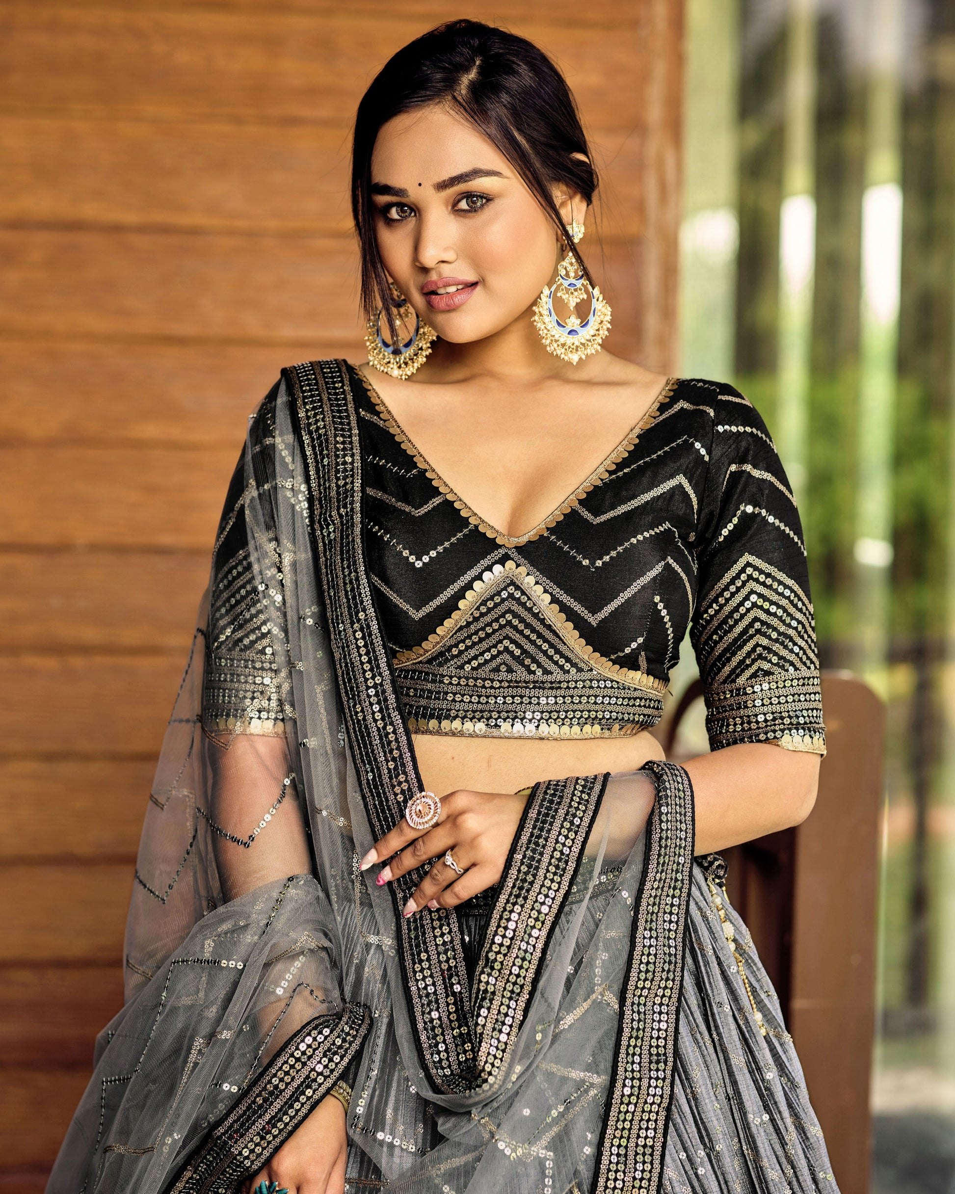 Woman wearing a black and gold saree with a blurred background