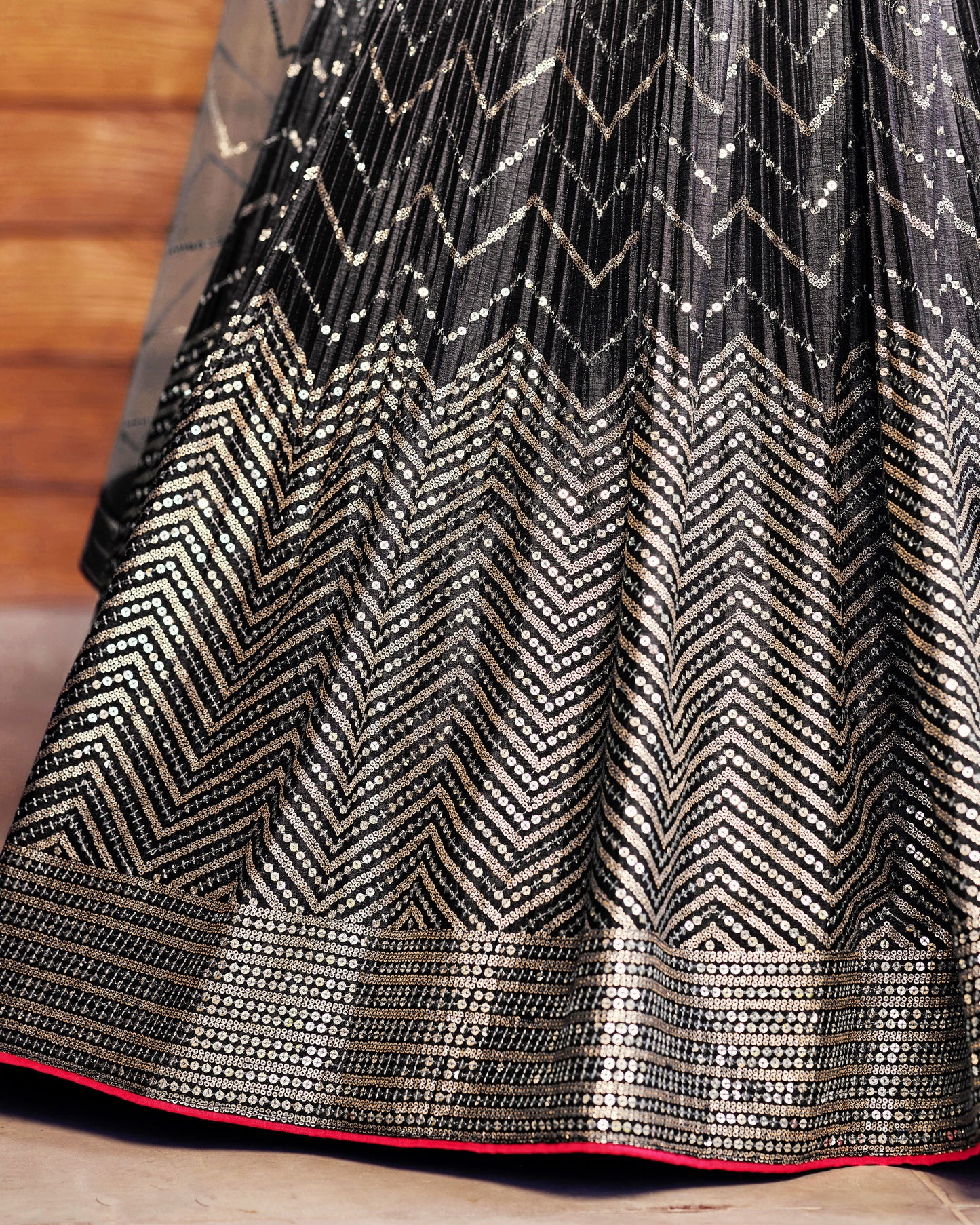 Black and gold patterned fabric with a chevron design on a wooden surface