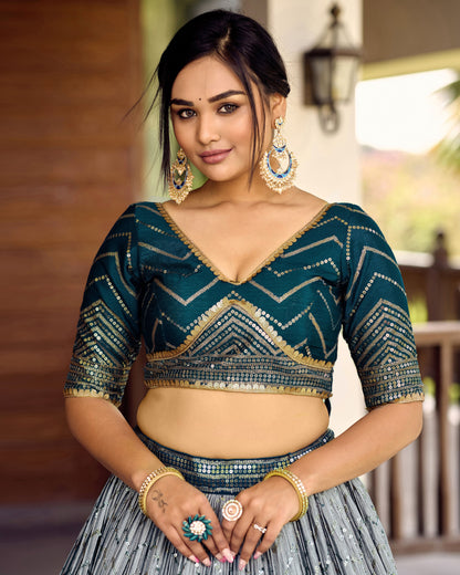 Woman wearing a traditional outfit with intricate designs in a blurred outdoor setting