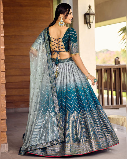 Woman in a traditional outfit with a gradient design, standing outdoors.