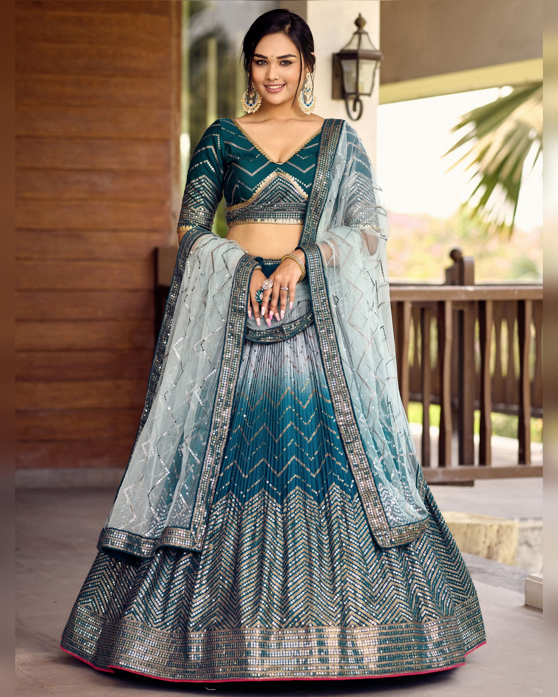 Woman wearing a traditional blue and gray lehenga with a matching blouse.
