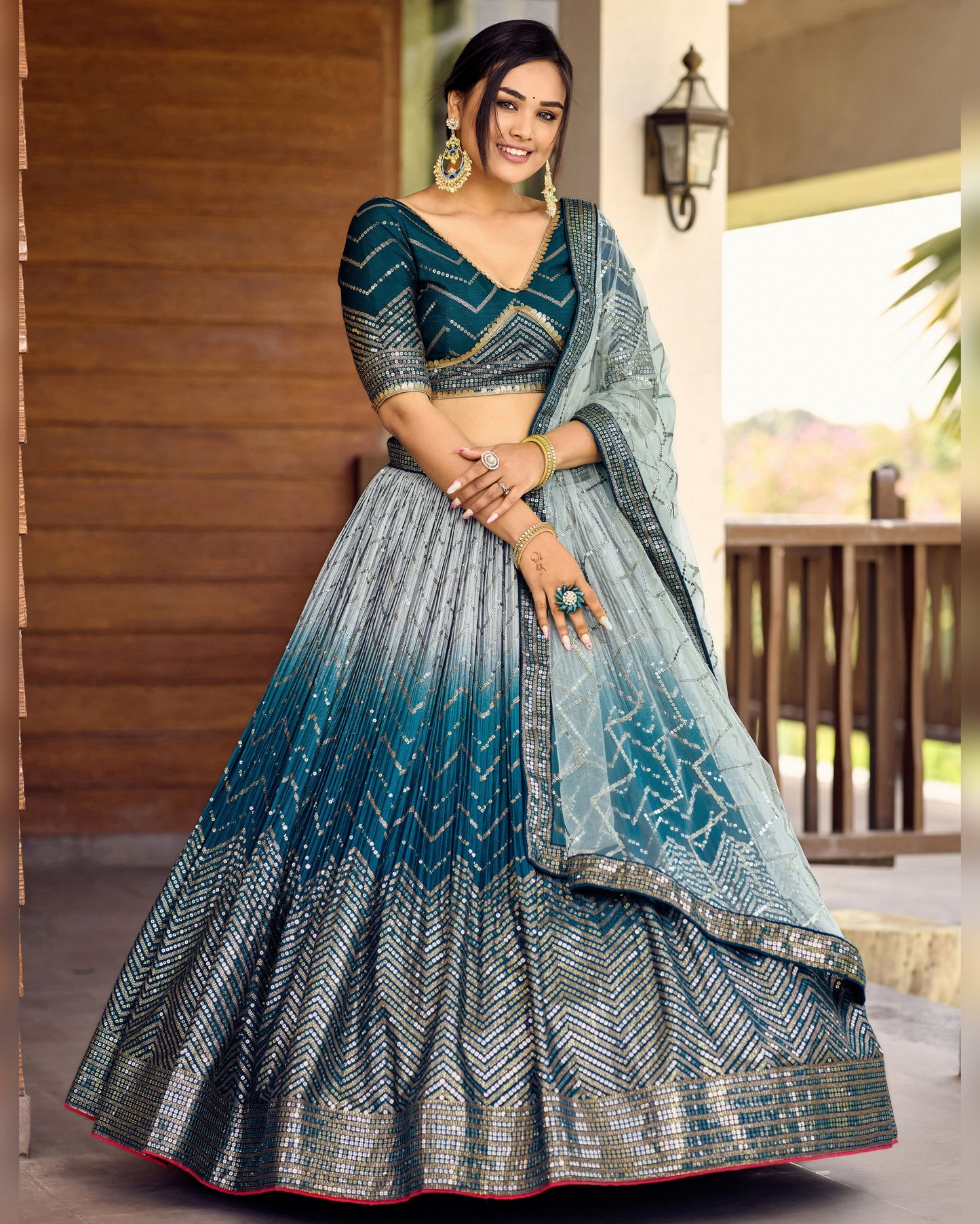 Woman wearing a traditional blue and gray lehenga with a blurred outdoor background