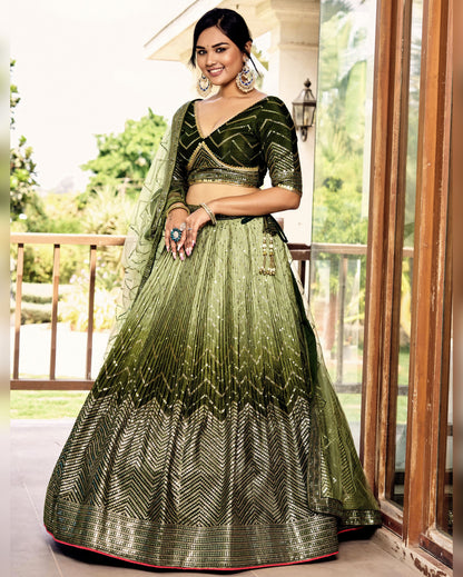 Woman in a green and black traditional outfit standing on a balcony.