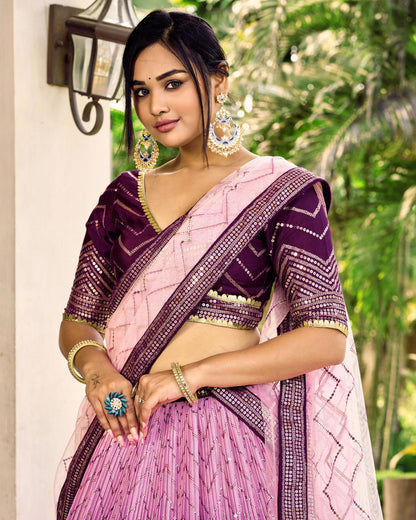 Woman wearing a pink and purple saree with jewelry outdoors