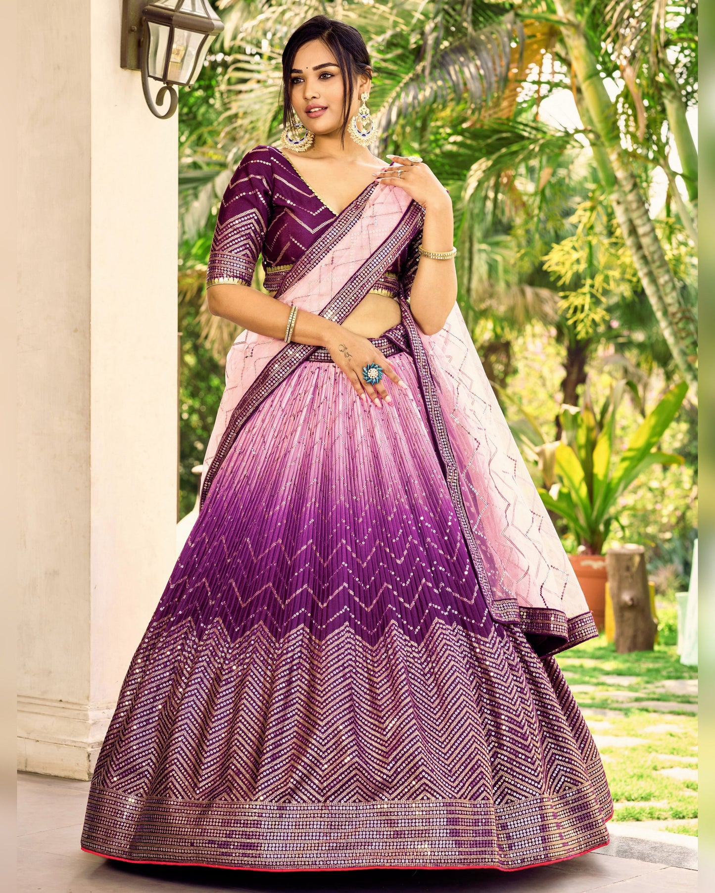 Woman wearing a purple and pink traditional outfit with a garden background