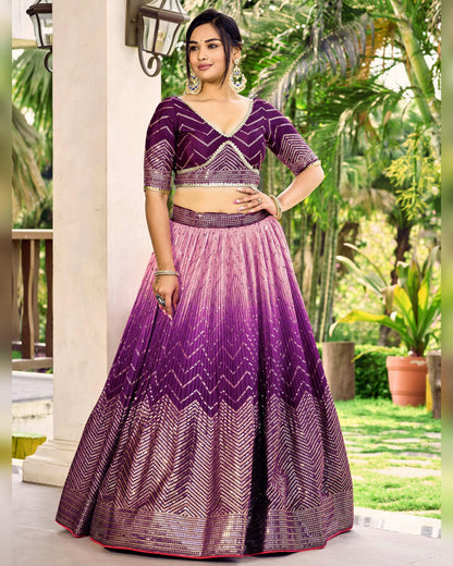 Woman wearing a purple and pink lehenga with a matching blouse in an outdoor setting.