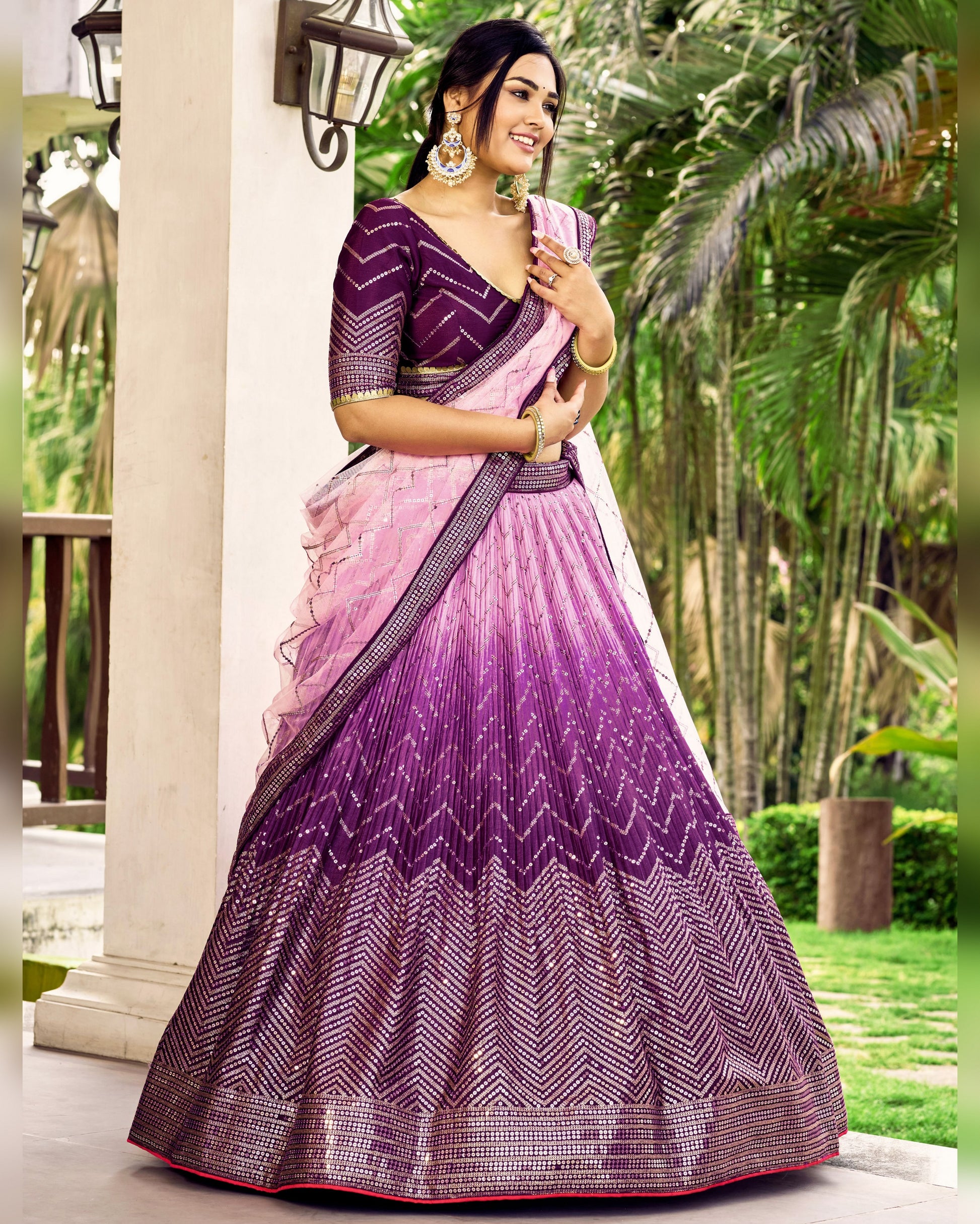 Woman wearing a purple and pink saree with a garden background