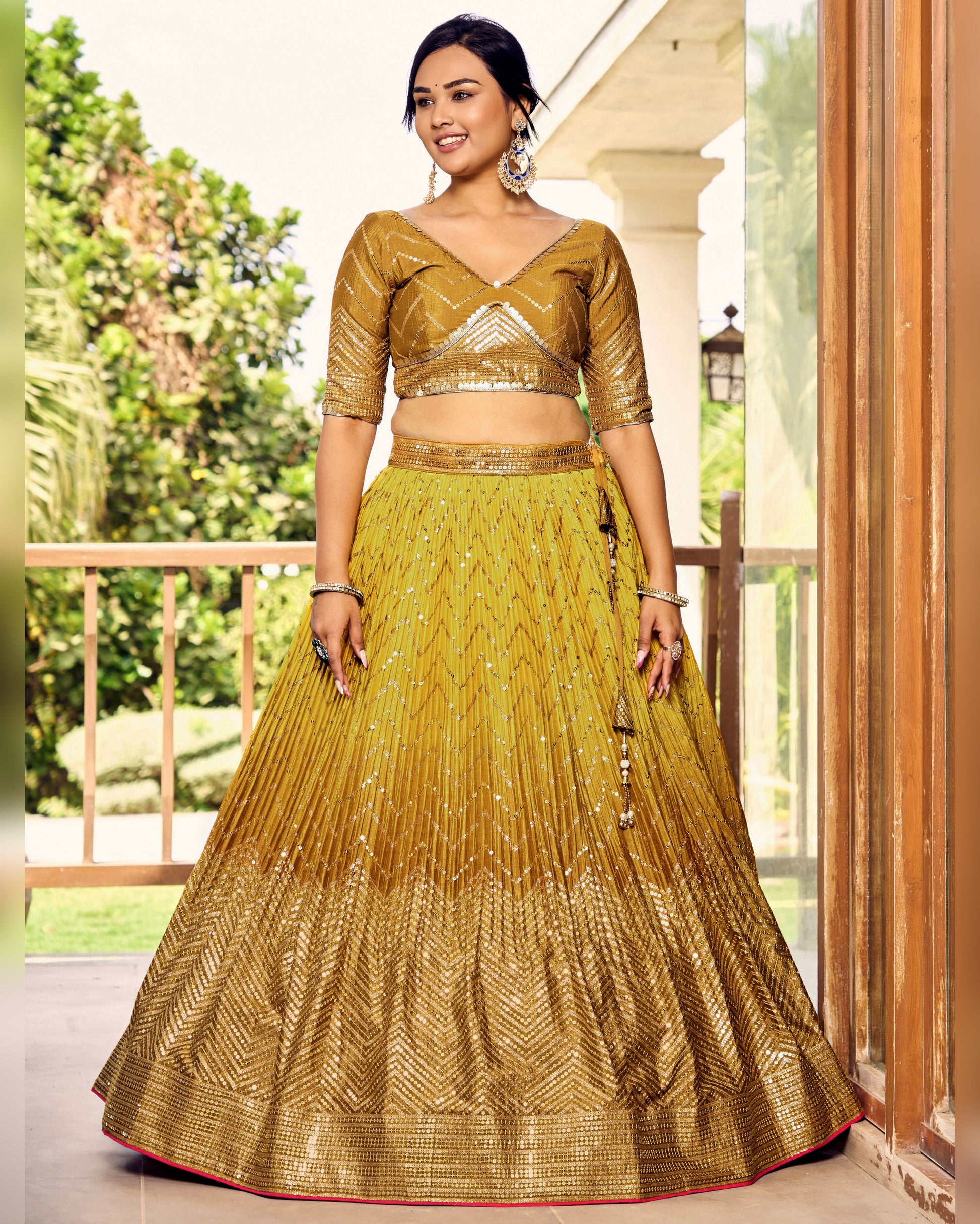 Woman wearing a gold traditional outfit with a skirt in an outdoor setting